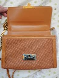 "Saffron Weave Luxe: Textured Clutch Bag with Twist-Lock Charm"