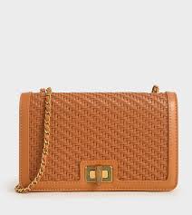 "Saffron Weave Luxe: Textured Clutch Bag with Twist-Lock Charm"